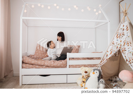 Happy cute daughter and young mother have online video call with father or grandmother using laptop Happy cute daughter and young mother have online video call with father or grandmother using laptop 94897702