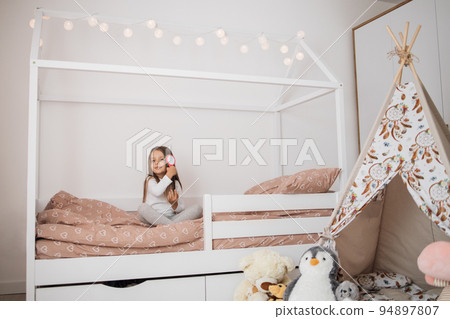 5 years old girl brushing her long hair in her bedroom in the morning. 5 years old girl brushing her long hair in her bedroom in the morning. 94897807