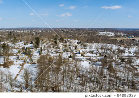 A small American town in Pennsylvania has a residential complex where the roofs have snow on them after a severe snowstorm in the area A small American town in Pennsylvania has a residential complex where the roofs have snow on them after a severe snowstorm in the area 94898059