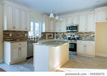 A newly constructed house was installed with white kitchen cabinets as part of the installation process 94898070