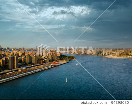 This panoramic view of Manhattan's skyline over the Manhattan Bridge on the Hudson River's horizon is from an aerial point of view of the city This panoramic view of Manhattan's skyline over the Manhattan Bridge on the Hudson River's horizon is from an aerial point of view of the city 94898080