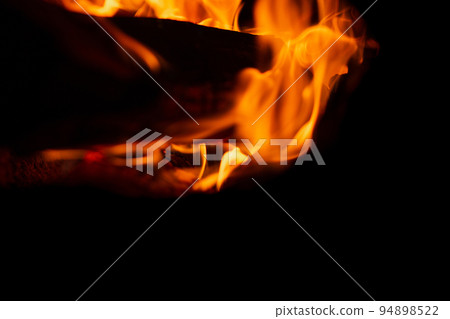 Burning firewood in the fireplace in the oven. Fire texture on black background Burning firewood in the fireplace in the oven. Fire texture on black background 94898522