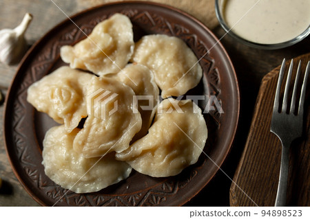Traditional Ukrainian dish varenyky with potatoes served in a bowl with sour cream and garlic Ravioli Traditional Ukrainian dish varenyky with potatoes served in a bowl with sour cream and garlic Ravioli 94898523