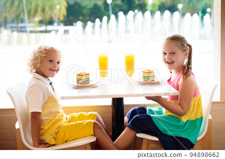 Kids eat cake at restaurant. Boy and girl in cafe. 94898662