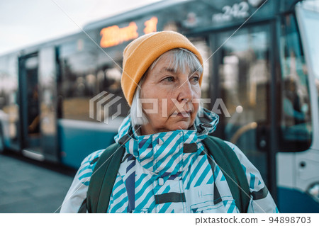 Senior woman on bus stop outdoors in city or town Senior woman on bus stop outdoors in city or town 94898703