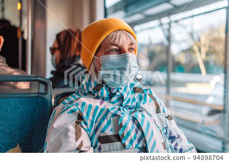 Mature European traveler senior woman wearing face mask at gate metro or subway train feeling alone while COVID-19 virus disease coronavirus outbreak. Mature European traveler senior woman wearing face mask at gate metro or subway train feeling alone while COVID-19 virus disease coronavirus outbreak. 94898704