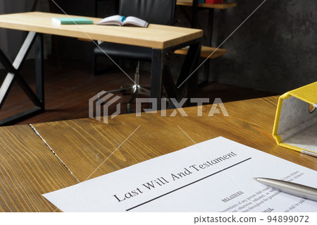 Papers with Last will and testament on the wooden surface. 94899072