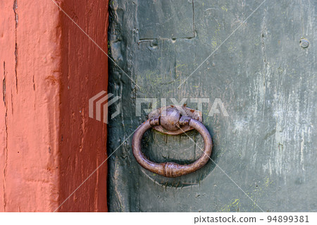 Antique wooden colorful door and lock deteriorated by time and rust in a colonial style house Antique wooden colorful door and lock deteriorated by time and rust in a colonial style house 94899381