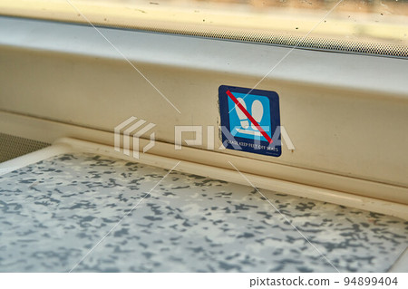 A sign indicating for passengers to keep their feet off of the seats A sign indicating for passengers to keep their feet off of the seats 94899404