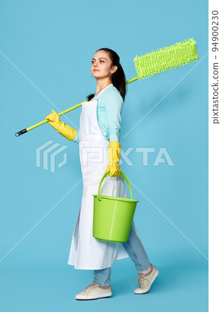 woman in rubber gloves holding mop and bucket and feeling 94900230