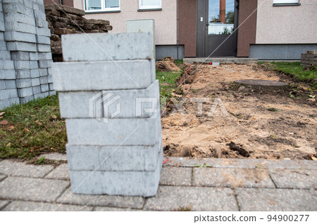 Pavement paving. Construction service. Entrance door of the apartment building 94900277