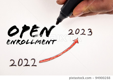 Open Enrollment. Text and a man's hand holding a black marker on a white background Open Enrollment. Text and a man's hand holding a black marker on a white background 94900288