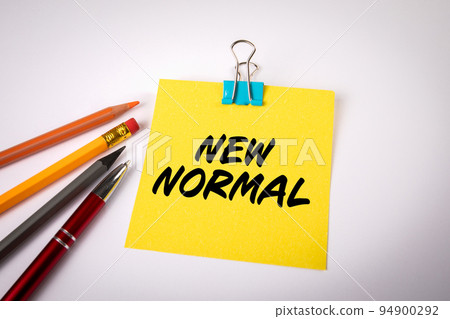 New Normal. Text on a yellow sheet of paper. White office desk 94900292