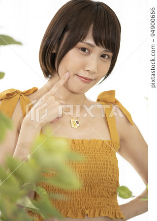 一個女人在一棵觀葉植物上擺姿勢 一個女人在一棵觀葉植物上擺姿勢 94900666