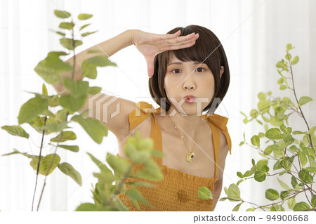一個女人在一棵觀葉植物上擺姿勢 94900668