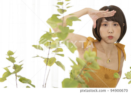 A woman posing over a foliage plant A woman posing over a foliage plant 94900670