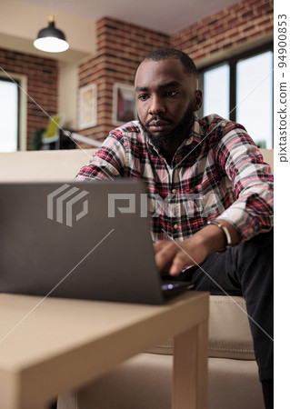 Office worker doing remote job on laptop, working on company startup online to find research data. Male freelancer browsing internet on computer, sending email to manager and doing task. 94900853