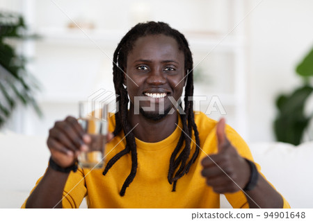 Cheerful Black Man Showing Glass Of Water And Thumb Up At Camera Cheerful Black Man Showing Glass Of Water And Thumb Up At Camera 94901648