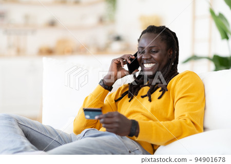 Online Banking. African American Guy Talking On Cellphone And Holding Credit Card 94901678