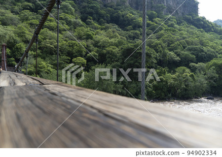 barranca huentitan, guadalajara, old wooden floor, wooden beams and crossbeams, mountains and tensioned cables, vegetation in the background 94902334