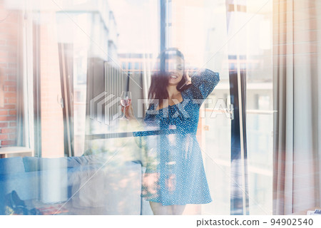 Lonely adorable dancing woman with glass of wine at cozy living room. Lonely adorable dancing woman with glass of wine at cozy living room. 94902540