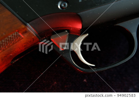 Trigger of a rifle on black background with red lightning Trigger of a rifle on black background with red lightning 94902583