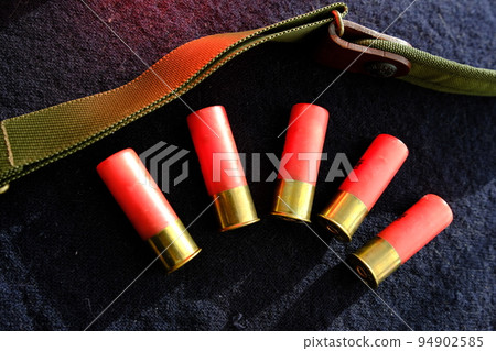 Shotgun shells on a black surface. Ammunition for 12 gauge smoothbore weapons. Hunting ammunition. Dark background. 94902585