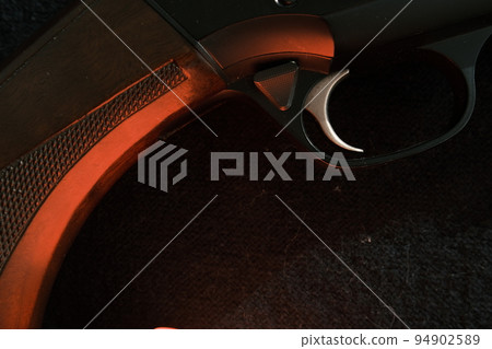Trigger of a rifle on black background with red lightning Trigger of a rifle on black background with red lightning 94902589