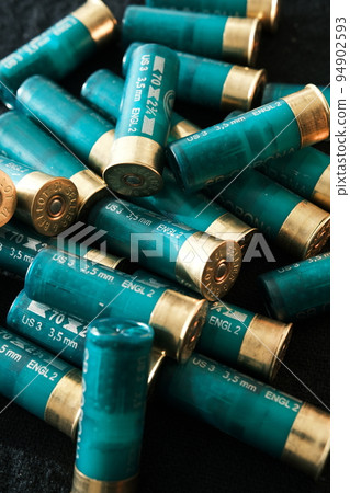 Shotgun shells on a black surface. Ammunition for 12 gauge smoothbore weapons. Hunting ammunition. Dark background. 94902593
