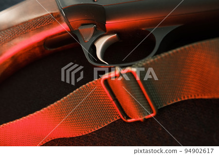 Trigger of a rifle on black background with red lightning 94902617