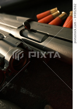 Closeup shotgun shutter. Hunting semi-automatic shotgun with wooden butt on dark background Closeup shotgun shutter. Hunting semi-automatic shotgun with wooden butt on dark background 94902682