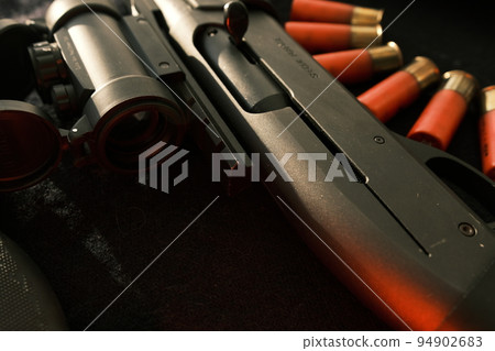Closeup shotgun shutter. Hunting semi-automatic shotgun with wooden butt on dark background Closeup shotgun shutter. Hunting semi-automatic shotgun with wooden butt on dark background 94902683