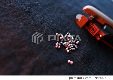Rifle gun break in two with air pellets for hunting on cloth dark background with red light close up of rifle shutter hole Rifle gun break in two with air pellets for hunting on cloth dark background with red light close up of rifle shutter hole 94902699