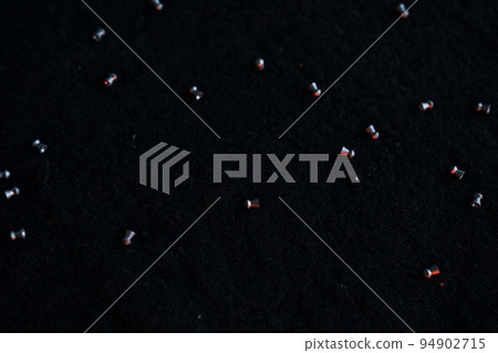 air gun pellets on darck cloth background with red light for illumination 94902715