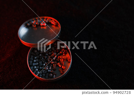 air gun pellets on darck cloth background with red light for illumination 94902728