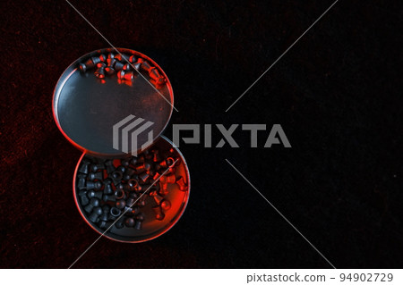 air gun pellets on darck cloth background with red light for illumination 94902729