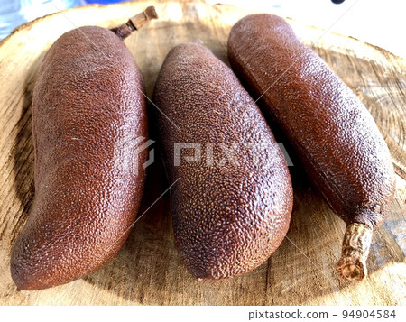 Fruit of the Jatoba tree, Hymenaea courbaril, under a banana leaf background. This fruit is widely used in folk medicine and the wood from this tree is one of the most valuable Fruit of the Jatoba tree, Hymenaea courbaril, under a banana leaf background. This fruit is widely used in folk medicine and the wood from this tree is one of the most valuable 94904584