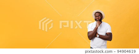 Human face expressions, emotions and feelings. Handsome young African American man looking up with thoughtful and skeptical expression, holding finger on his chin, trying to remember something. 94904619