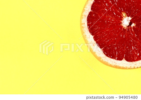Close-up on half of orange  under yellow background 94905480