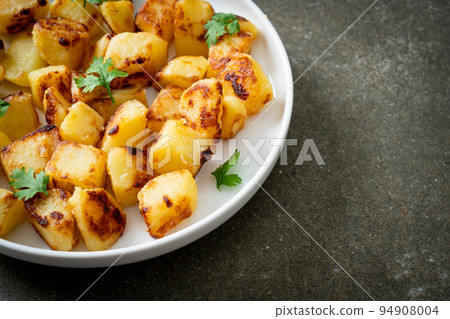 Roasted or grilled potatoes on plate Roasted or grilled potatoes on plate 94908004