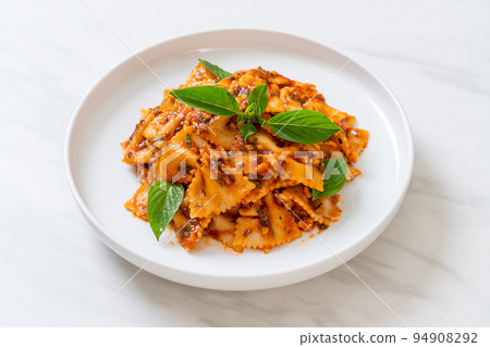 farfalle pasta with basil and garlic in tomato sauce 94908292