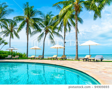 Beautiful tropical beach and sea with umbrella and chair around swimming pool in hotel resort Beautiful tropical beach and sea with umbrella and chair around swimming pool in hotel resort 94909893