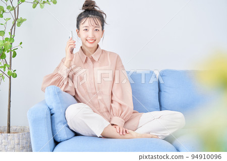 Young woman using smart phone in the room Young woman using smart phone in the room 94910096