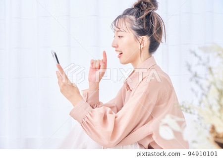 Young woman using smart phone in the room Young woman using smart phone in the room 94910101