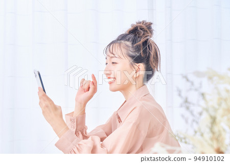 年輕女子在房間裡使用智能手機 年輕女子在房間裡使用智能手機 94910102