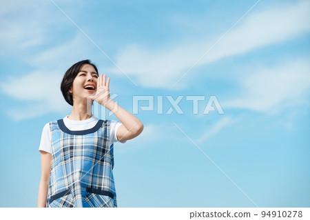 A nursery teacher calling a kindergartener under the blue sky 94910278
