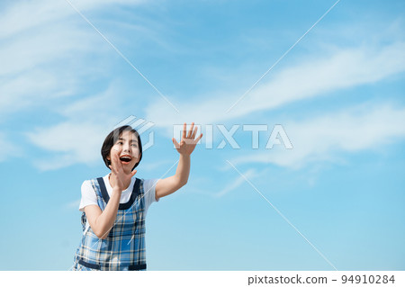 A nursery teacher calling a kindergartener under the blue sky 94910284
