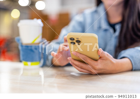 Woman hold with mobile phone at outdoor cafe Woman hold with mobile phone at outdoor cafe 94911013