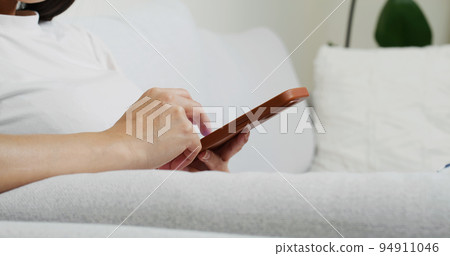 Woman use of mobile phone and sit on sofa 94911046