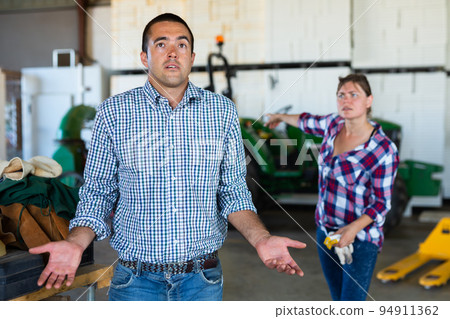 Female farm owner dissatisfied with the work of hired male worker Female farm owner dissatisfied with the work of hired male worker 94911362